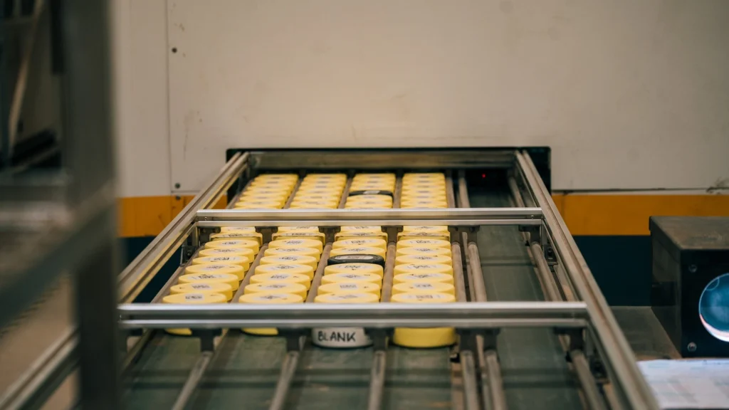 Rows of labelled ore sample jars queued on the automated conveyor system of a PhotonAssay™ unit at Ravenswood Gold Mine