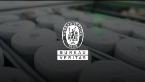 Ore sample jars on a PhotonAssay™ conveyor system with Bureau Veritas logo overlaid