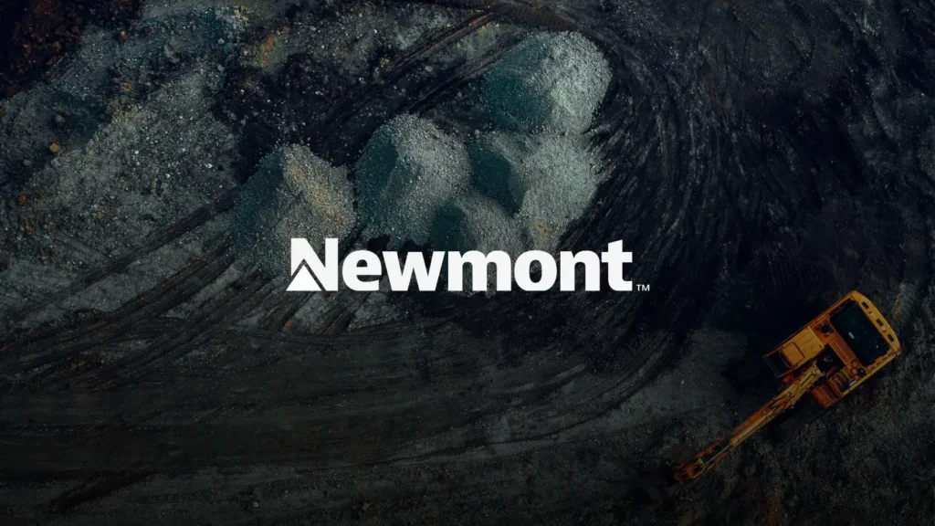 Aerial view of an open pit gold mine with a haul truck, with Newmont logo overlaid