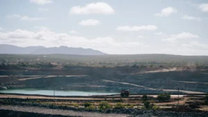 Aerial view of the open-cut Ravenswood Gold Mine in Queensland, Australia, with a large tailings pond and arid landscape in the background