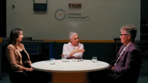 Dr Naomi Potter, Dr Simon Dominy, and Dr James Tickner in discussion in front of PhotonAssay™ unit at Chrysos Corporation headquarters