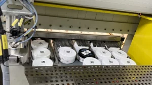 Multiple QR-coded ore sample jars queued on the automated conveyor system inside a PhotonAssay™ unit