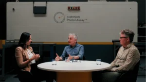 Dr Naomi Potter, Dr Simon Dominy, and Dr James Tickner in discussion in front of PhotonAssay™ unit at Chrysos Corporation headquarters